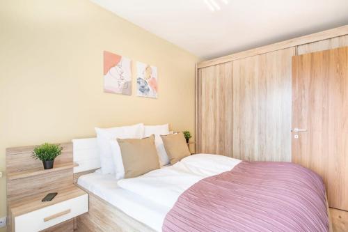 1 dormitorio con 1 cama blanca grande y armarios de madera en JACUZZI on Terrace - Unique Home en Budapest