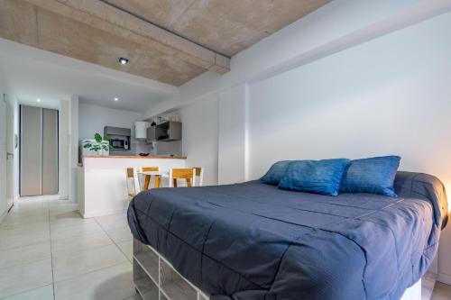 a bedroom with a large bed with blue pillows at Dpto. nuevo en San Telmo - BA 14 in Buenos Aires