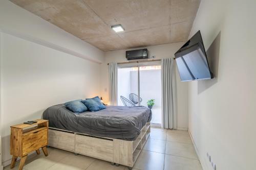 a bedroom with a bed and a flat screen tv at Dpto. nuevo en San Telmo - BA 14 in Buenos Aires
