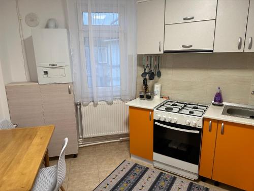 kuchnia z pomarańczowo-białym piecem i stołem w obiekcie Apartament Amalia w mieście Roman
