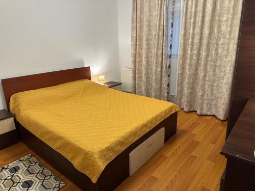 a bedroom with a bed with a yellow bedspread at Apartament Amalia in Roman
