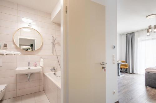 Baño blanco con lavabo y espejo en Modern Comfy Stay next to the River en Budapest