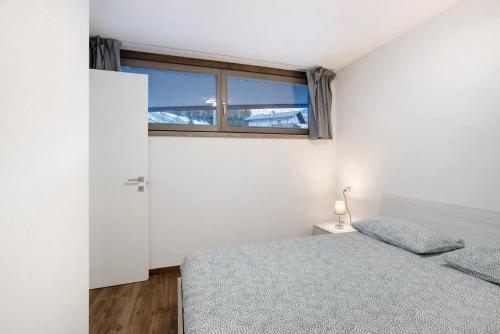 1 dormitorio con cama y ventana en SAN CARLO 1, en Valdidentro