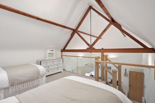 a attic bedroom with two beds and a mirror at Squirrel Lodge - 2 Bed Country Home in Market Harborough