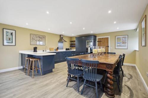a large kitchen with a wooden table and chairs at Sophie's Barn - Hot Tub Packages Available in Market Harborough