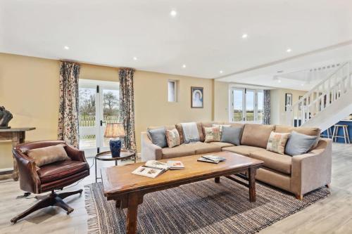 a living room with a couch and a table at Sophie's Barn - Hot Tub Packages Available in Market Harborough