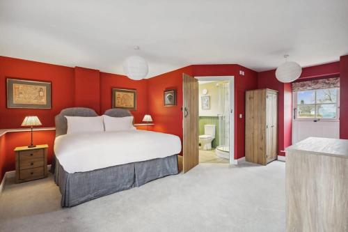 a bedroom with a large bed and red walls at Sophie's Barn - Hot Tub Packages Available in Market Harborough