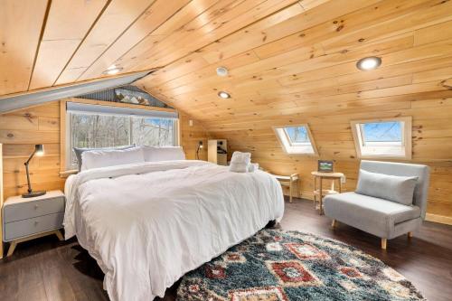 a bedroom with a large bed and a chair at Redwoods Rising - Sweeping Views-Hot Tub in West Fork