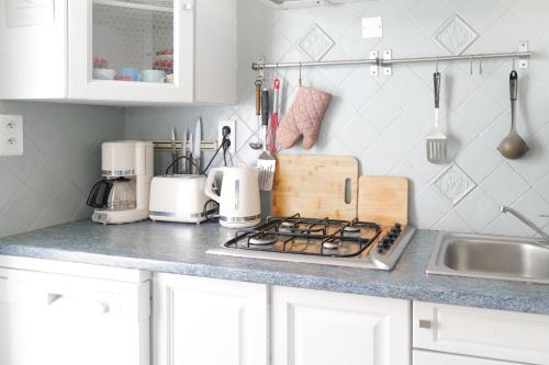 Il comprend une cuisine équipée d'une cuisinière. four supérieur à côté d'un évier dans l'établissement Belle maison de vacances à la Pironnière - 6 à 8 pers, à Les Sables-dʼOlonne