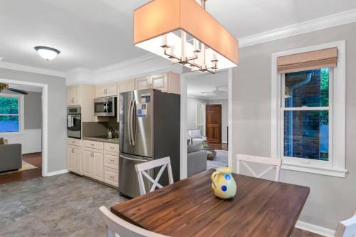 a kitchen with a wooden table and a refrigerator at The Quails Nest of Harbison in Columbia