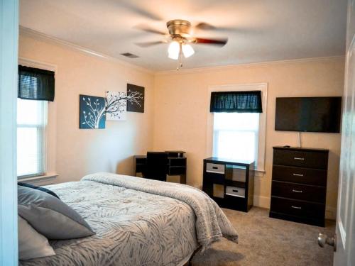 een slaapkamer met een bed en een plafondventilator bij Serenity in the Suburbs in Columbia