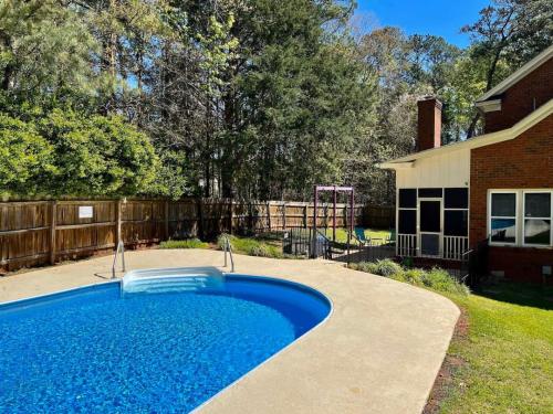 a swimming pool in a yard next to a house at Serenity in the Suburbs in Columbia