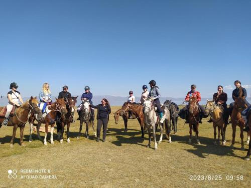 een groep mensen die paardrijden in een veld bij Zalkar Yurt Camp in Song-Kul