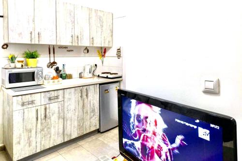 a kitchen with a microwave and a tv in it at דירה רומנטית ברחוב בוגרשוב ליד הים in Tel Aviv