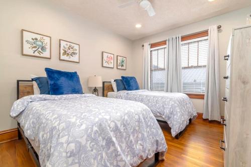 two beds in a bedroom with blue pillows at 3BR Bristol Retreat - 2 Blocks from State Street in Bristol