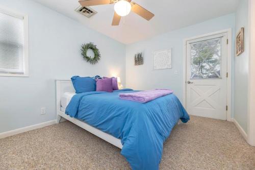 een slaapkamer met een bed met blauwe en paarse kussens bij Relax in this 4BR 3BA Boone Lake front cottage in Piney Flats