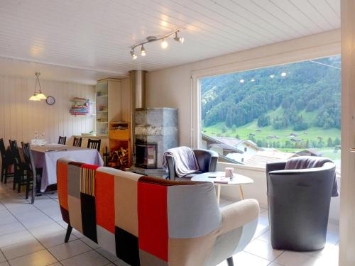 ein Restaurant mit einem Tisch und Stühlen sowie einem großen Fenster in der Unterkunft Holiday Home Chalet Guldeli by Interhome in Kandergrund
