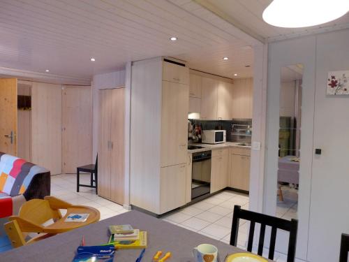 a kitchen and living room with a table and chairs at Holiday Home Chalet Guldeli by Interhome in Kandergrund