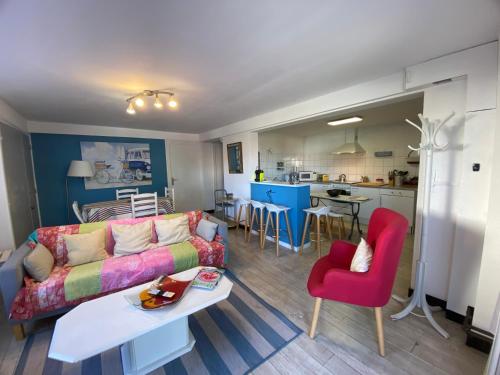 un salon avec un canapé et une table et une cuisine dans l'établissement Spacieuxappartement, à Hendaye