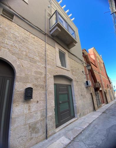 a brick building with a green door and a window at La Maison de Rosaline Rooms in Barletta