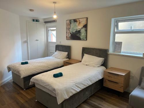 um quarto com 2 camas e uma janela em Elegant Central Luton Studio - Contractors/Airport Travellers! em Luton