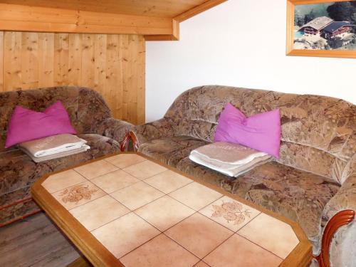 ein Wohnzimmer mit einem Sofa und rosa Kissen in der Unterkunft Apartment Kammerlander - NKI135 by Interhome in Neukirchen am Großvenediger