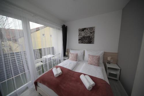 een slaapkamer met een bed en een groot raam bij ****Heviz Springs Apartments in Hévíz