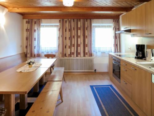 eine Küche mit einem langen Holztisch und Bänken in der Unterkunft Apartment Fiechter - FGZ350 by Interhome in Bruck am Ziller