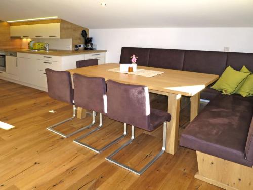 a dining room table with chairs and a couch at Apartment Schoppengrub - BMG196 by Interhome in Bramberg am Wildkogel
