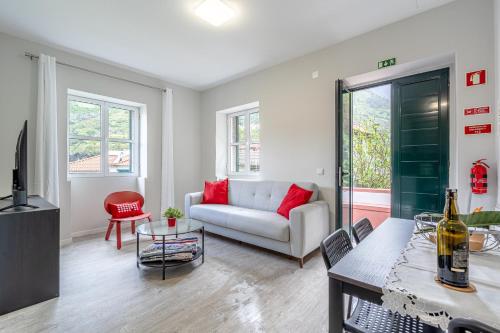 a living room with a couch and a table at JMF House in São Vicente