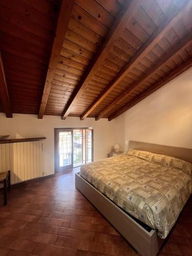sypialnia z łóżkiem w pokoju z drewnianym sufitem w obiekcie Home 26, near the lake w mieście Valmadrera
