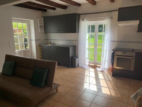 un salon avec un canapé et une cuisine dans l'établissement Le Bois D'amour gite et chambres, à Charroux