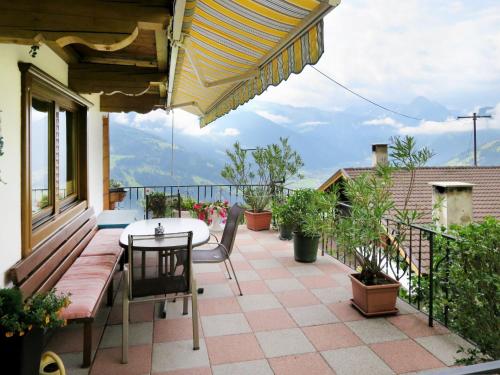 a patio with a table and chairs on a balcony at Apartment Bloserhof by Interhome in Zellberg