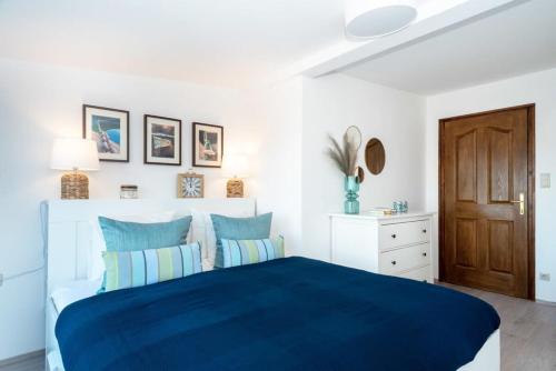 a bedroom with a blue bed and a wooden door at Tóparti villa, közvetlen vízkapcsolattal in Siófok