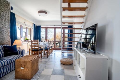 a living room with a couch and a tv and a table at Tóparti villa, közvetlen vízkapcsolattal in Siófok