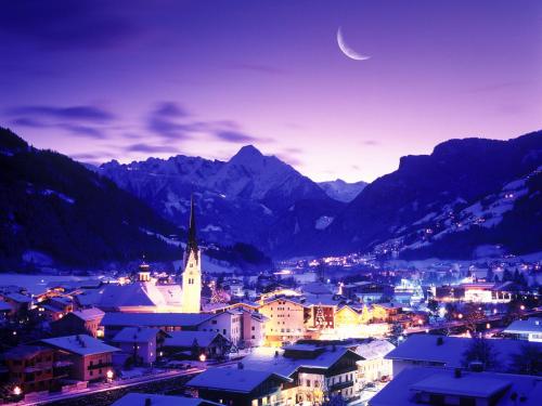 a view of a town at night with a moon at Apartment Bloserhof by Interhome in Zellberg