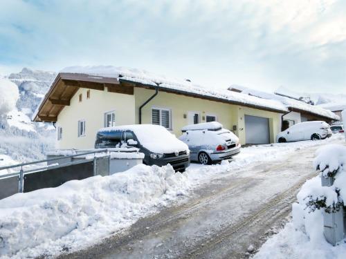 a house covered in snow with cars parked in it at Apartment Stefan-1 by Interhome in Hippach