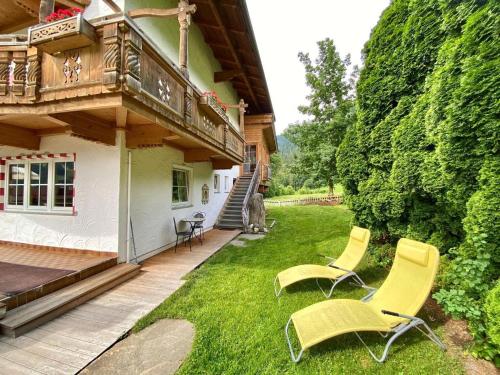 a yard with two chairs and a balcony at Apartment Sonneck - MHO554 by Interhome in Ramsau im Zillertal