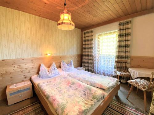 Schlafzimmer mit einem Bett, einem Tisch und einem Fenster in der Unterkunft Apartment Schusterhäusl - MHO756 by Interhome in Schwendau