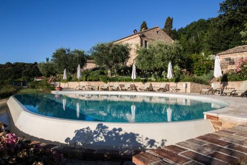 a swimming pool with chairs and umbrellas at Pamperduto Country Resort in Porto Potenza Picena