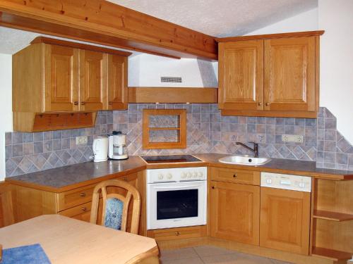- une cuisine avec des placards en bois et un évier dans l'établissement Apartment Prieslern - BMG192 by Interhome, à Bramberg am Wildkogel