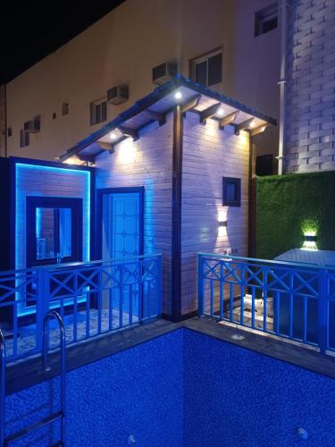 une petite maison avec terrasse la nuit dans l'établissement اكواخ الماريا, à Arar