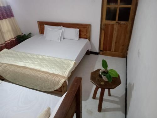 1 Schlafzimmer mit 2 Betten und einem kleinen Tisch in der Unterkunft Diyathalawa The Mountain Lodge in Ellealutwela