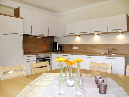 uma cozinha com uma mesa com flores em vasos em Apartment Talmoosen-Bauer - BMG210 by Interhome em Bramberg am Wildkogel