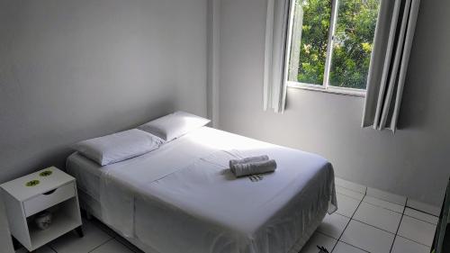ein kleines Bett in einem Zimmer mit Fenster in der Unterkunft Ed Bertholi - Vista lateral do mar com garagem in Serra