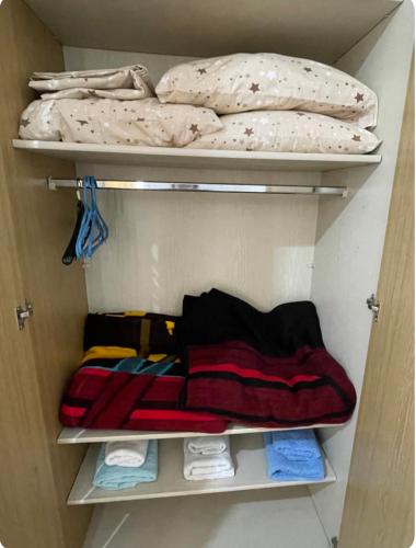 a closet filled with lots of towels and pillows at Seaside Apartments Golem in Golem
