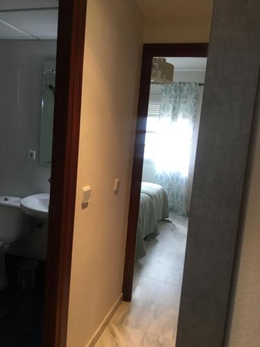 a bathroom with a door leading to a bedroom at Alojamiento Seda in Alcalá de Guadaira