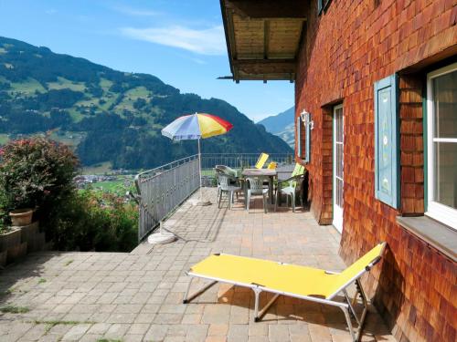 a patio with a yellow bench and an umbrella at Chalet Jenneweinhütte - ZAZ408 by Interhome in Zell am Ziller