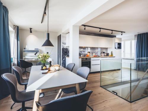 una cucina e una sala da pranzo con tavolo e sedie bianchi di Apartment Mariandl am Meer-4 by Interhome a Binz