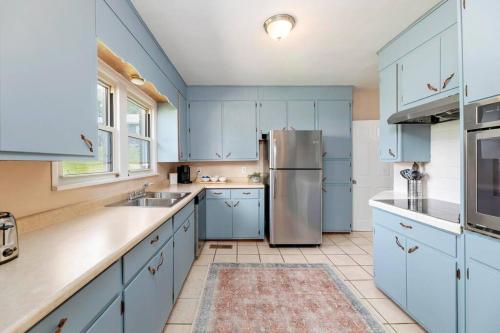 uma cozinha com armários azuis e um frigorífico de aço inoxidável em 'My Tennessee Mountain Home' in Kingsport em Kingsport